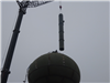 Larger crane placing the water tube inside the water tower
